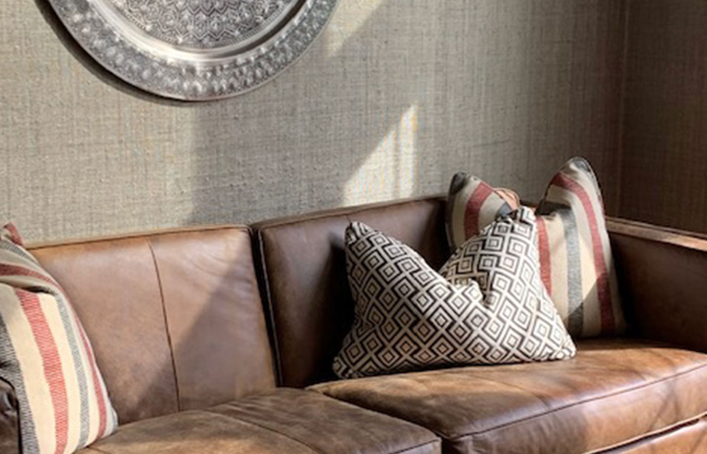 detail of leather couch with patterned pillows